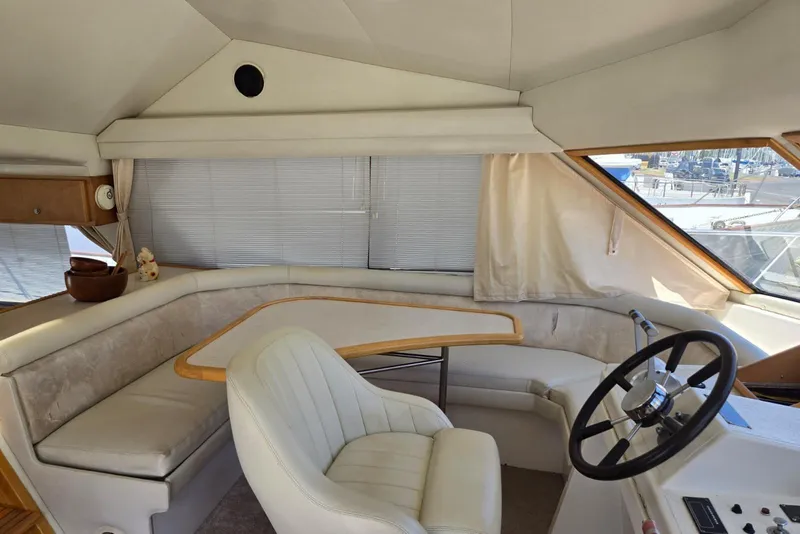 Slide: The Image of 1994 Navigator 5600 yacht interior with steering wheel, seating area, and windows. - 40