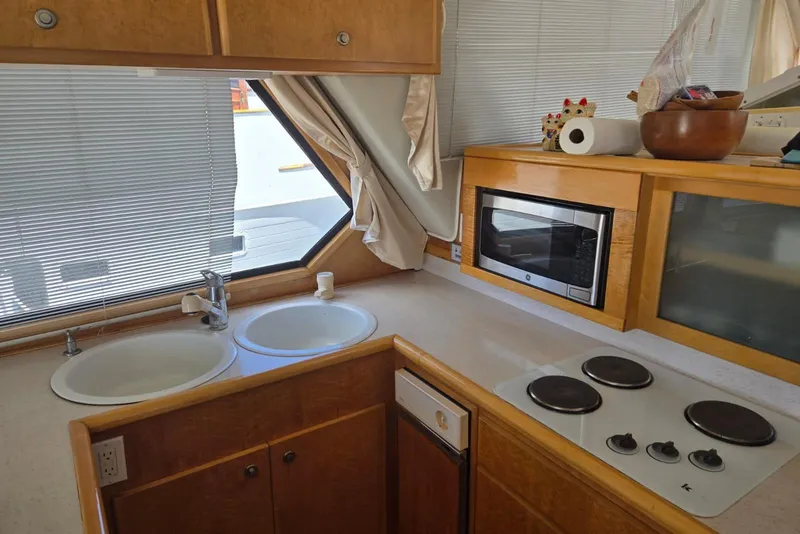 Slide: The Image of Compact kitchen in a 1994 Navigator 5600 yacht with stove, microwave, and dual sinks. - 8