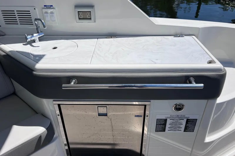 Slide: The Image of 2022 Sea Ray Sundancer 320 Coupe Outboard boat kitchenette with sink and storage. - 17