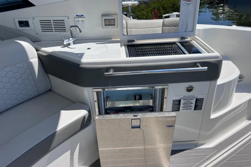 Slide: The Image of 2022 Sea Ray Sundancer 320 Coupe Outboard boat interior with kitchenette and seating area. - 18