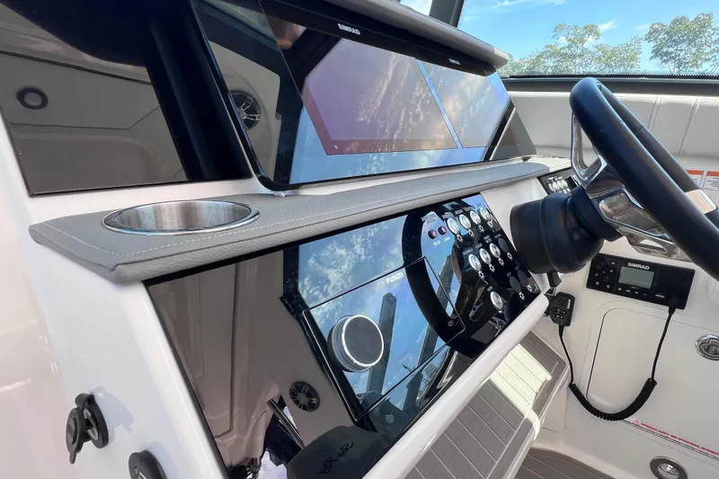 Slide: The Image of 2022 Sea Ray Sundancer 320 Coupe Outboard helm with modern controls and steering wheel. - 26