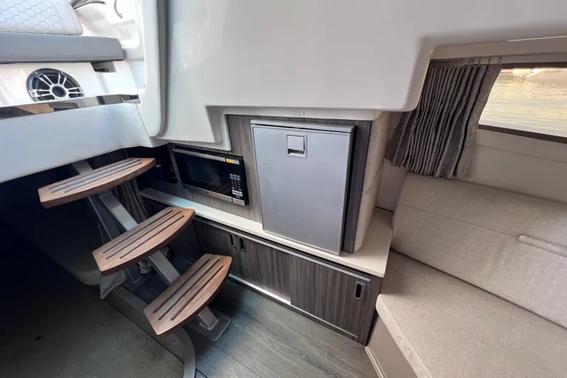 Slide: The Image of Interior of 2022 Sea Ray Sundancer 320 Coupe Outboard with stairs, microwave, and seating area. - 44