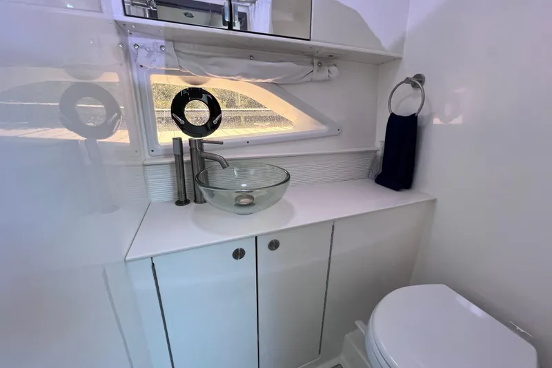 Slide: The Image of 2022 Sea Ray Sundancer 320 Coupe Outboard bathroom with modern sink and toilet. - 47