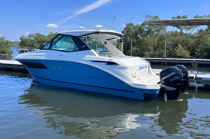 Slide: The Image of 2022 Sea Ray Sundancer 320 Coupe Outboard docked on calm water. - 7