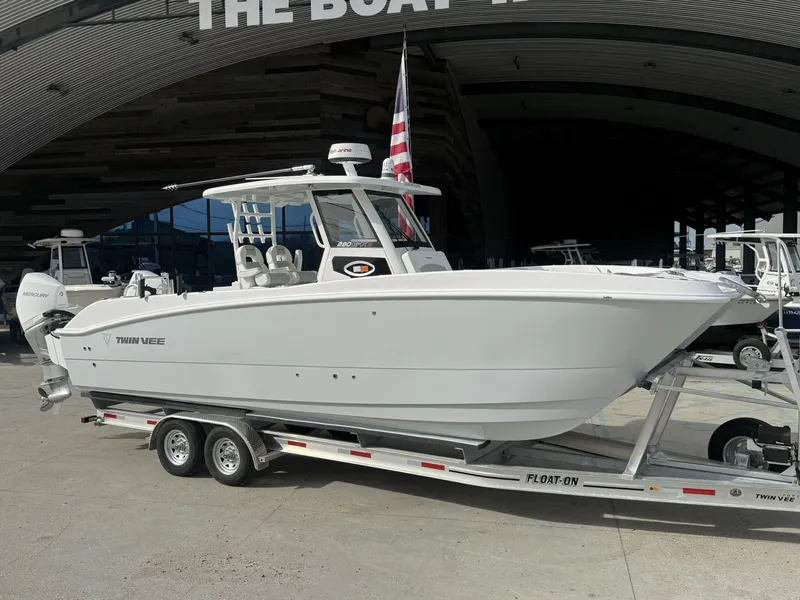 Slide: The Image of 2026 Twin Vee 280 GFX2 boat on trailer outside showroom. - 15