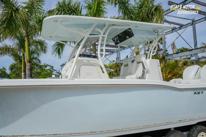 Slide: The Image of 2026 Key West 291 FS boat with T-top, parked near palm trees. - 4