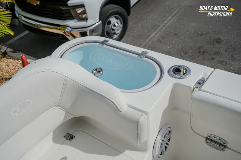 Slide: The Image of 2026 Key West 291 FS boat interior with seating and storage, parked near a vehicle. - 43
