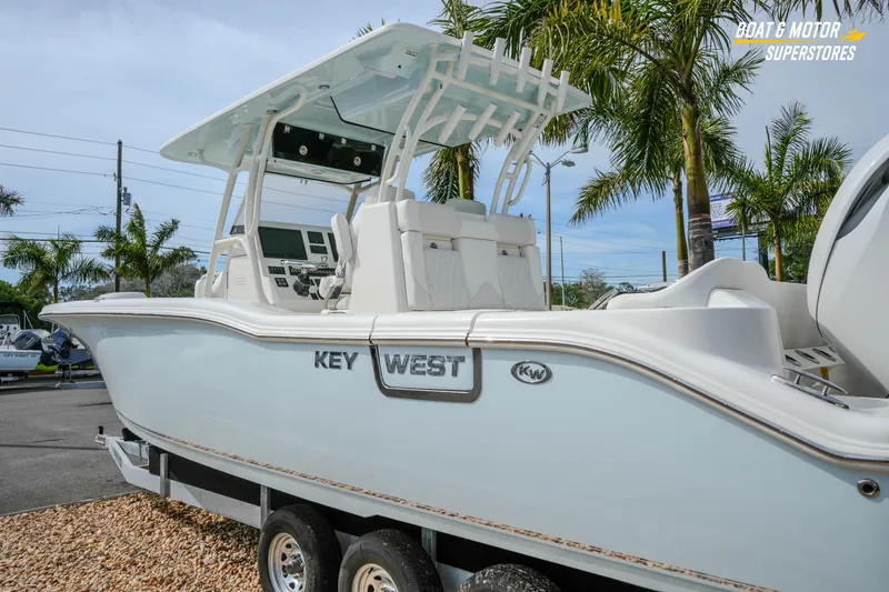 Slide: The Image of 2026 Key West 291 FS boat on trailer, surrounded by palm trees. - 6