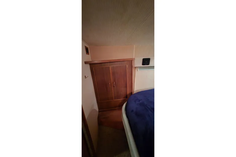 Slide: The Image of Interior cabin of 1987 Sea Ray 340 Sedan Bridge with wooden closet and bed. - 14