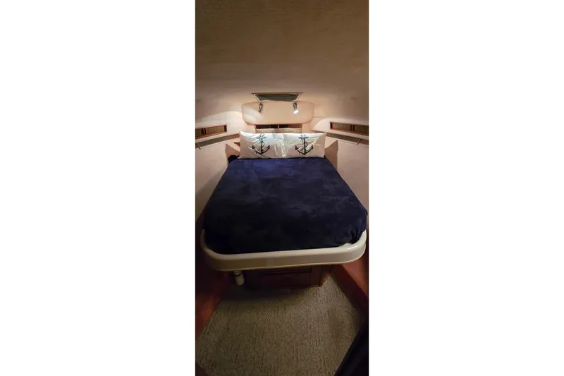 Slide: The Image of Cozy cabin interior of 1987 Sea Ray 340 Sedan Bridge with nautical-themed bedding. - 15