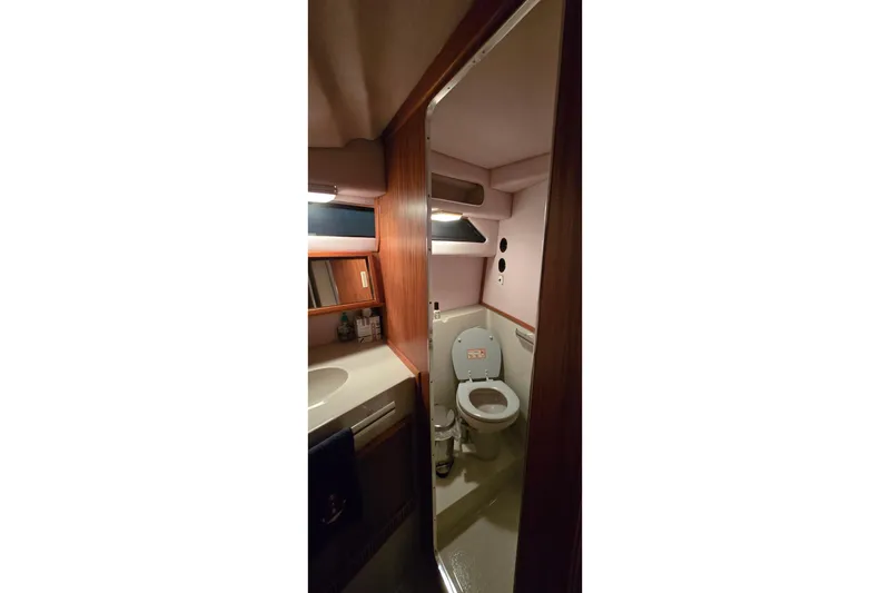 Slide: The Image of 1987 Sea Ray 340 Sedan Bridge bathroom interior with toilet and sink. - 17
