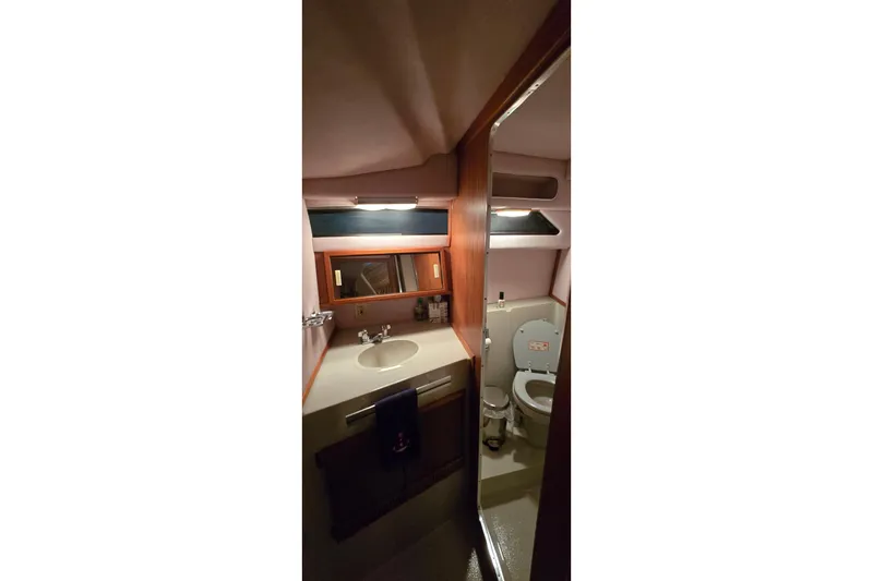 Slide: The Image of 1987 Sea Ray 340 Sedan Bridge bathroom with sink, mirror, and toilet. - 18