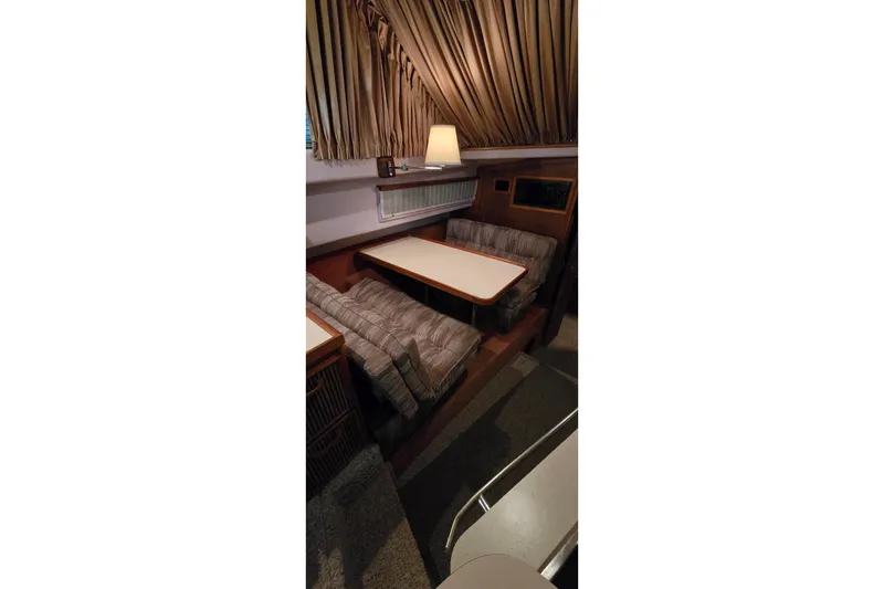 Slide: The Image of Interior of 1987 Sea Ray 340 Sedan Bridge with cozy seating and table. - 21
