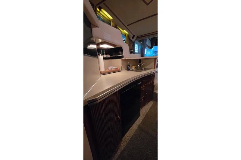 Slide: The Image of Interior view of 1987 Sea Ray 340 Sedan Bridge kitchen area with sink and cabinets. - 22