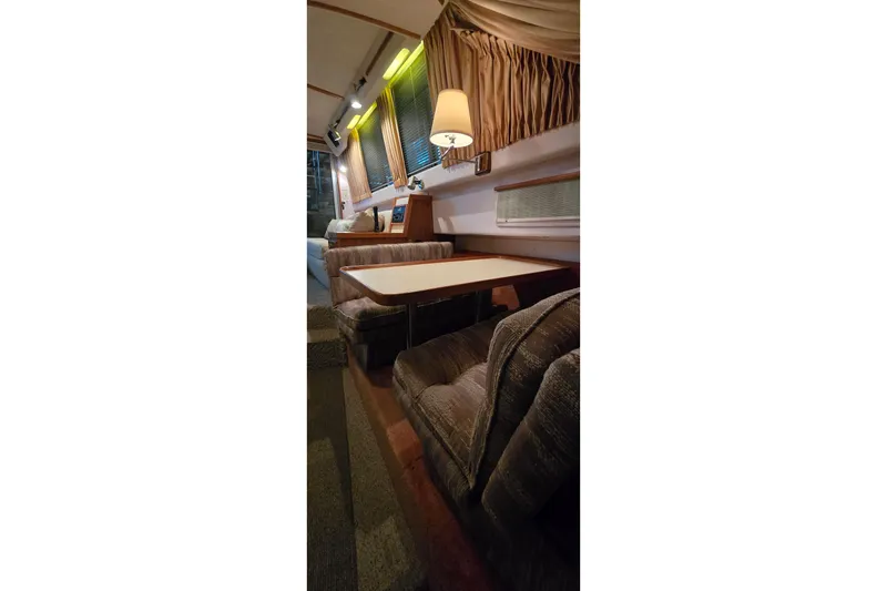 Slide: The Image of Interior of 1987 Sea Ray 340 Sedan Bridge with cozy seating and dining area. - 23