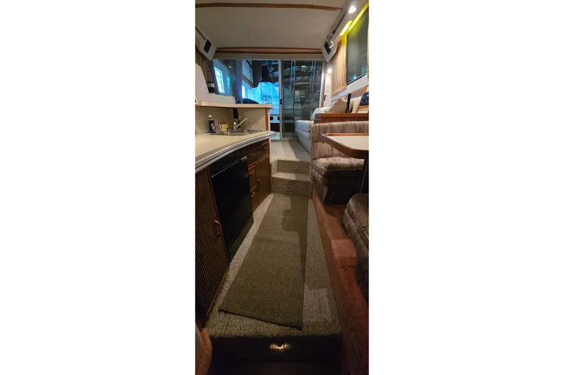 Slide: The Image of Interior of 1987 Sea Ray 340 Sedan Bridge, featuring kitchen and seating area. - 24
