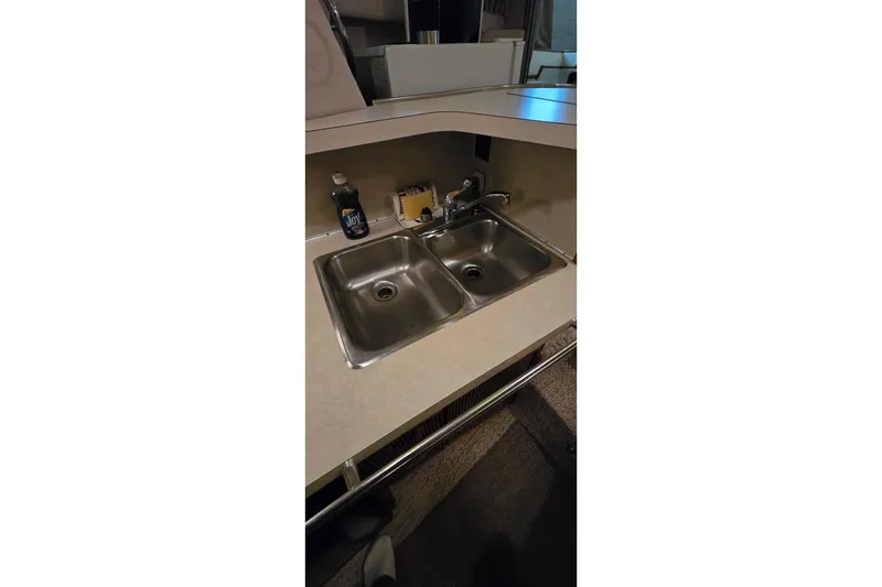 Slide: The Image of 1987 Sea Ray 340 Sedan Bridge kitchen sink with dual basins and countertop. - 26