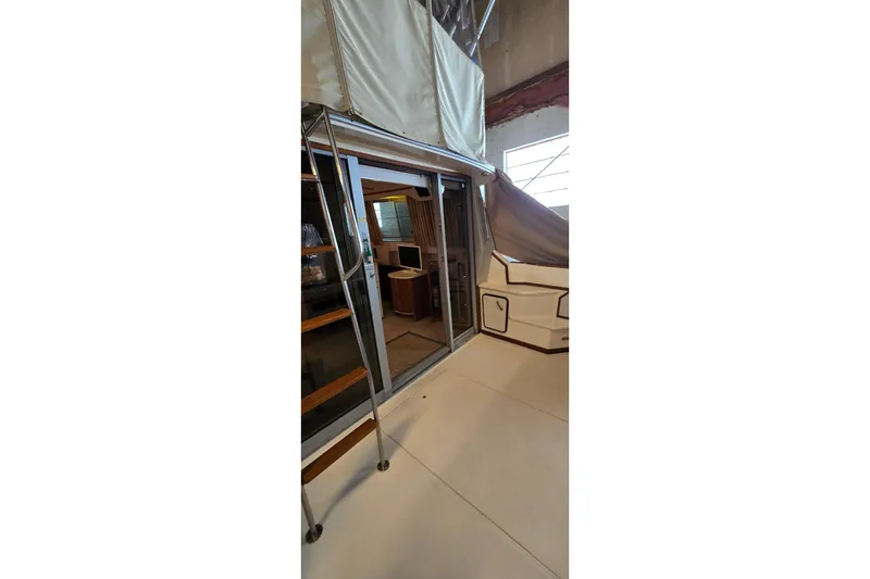 Slide: The Image of 1987 Sea Ray 340 Sedan Bridge interior view with sliding glass door and ladder. - 37