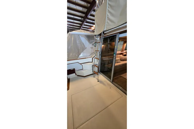 Slide: The Image of 1987 Sea Ray 340 Sedan Bridge interior with ladder and sliding glass door. - 38