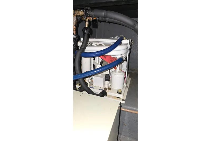 Slide: The Image of Engine compartment of a 1987 Sea Ray 340 Sedan Bridge with visible hoses and components. - 49