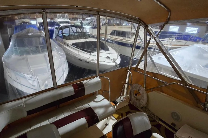 Slide: The Image of 1987 Sea Ray 340 Sedan Bridge interior view, showcasing docked boats in a marina setting. - 7