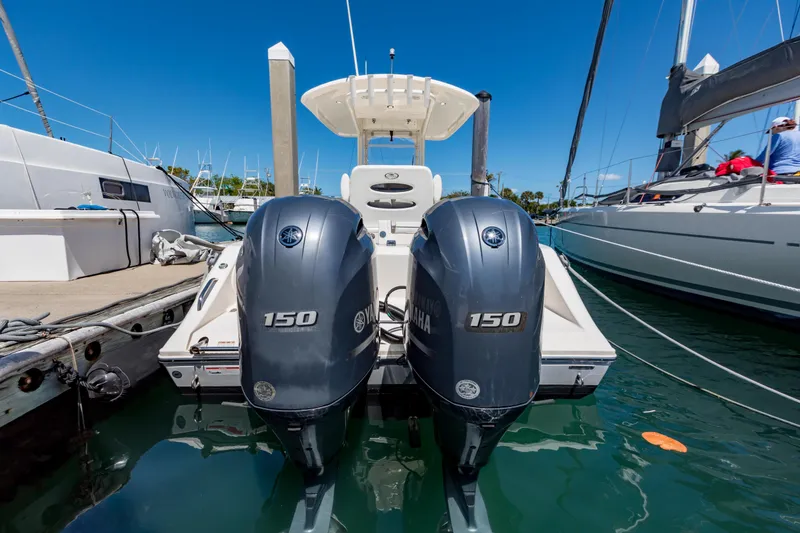Slide: The Image of 2023 Cobia 240 Center Console with twin Yamaha 150 engines docked at marina. - 10