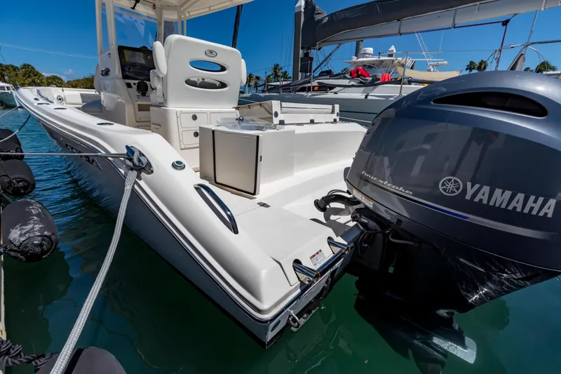 Slide: The Image of 2023 Cobia 240 Center Console boat with Yamaha engine docked in marina. - 12