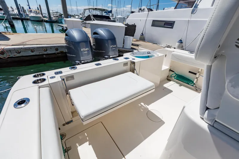 Slide: The Image of 2023 Cobia 240 Center Console boat with twin engines docked at marina. - 15