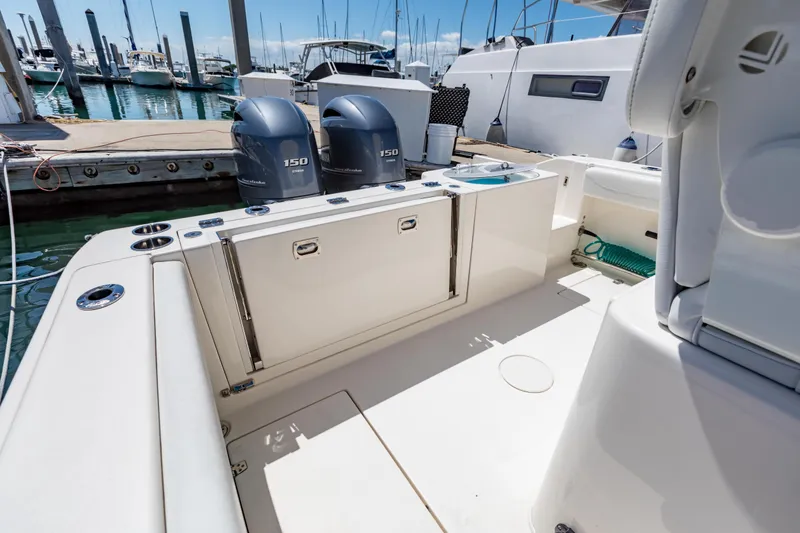 Slide: The Image of 2023 Cobia 240 Center Console boat interior with twin 150 engines at marina. - 16