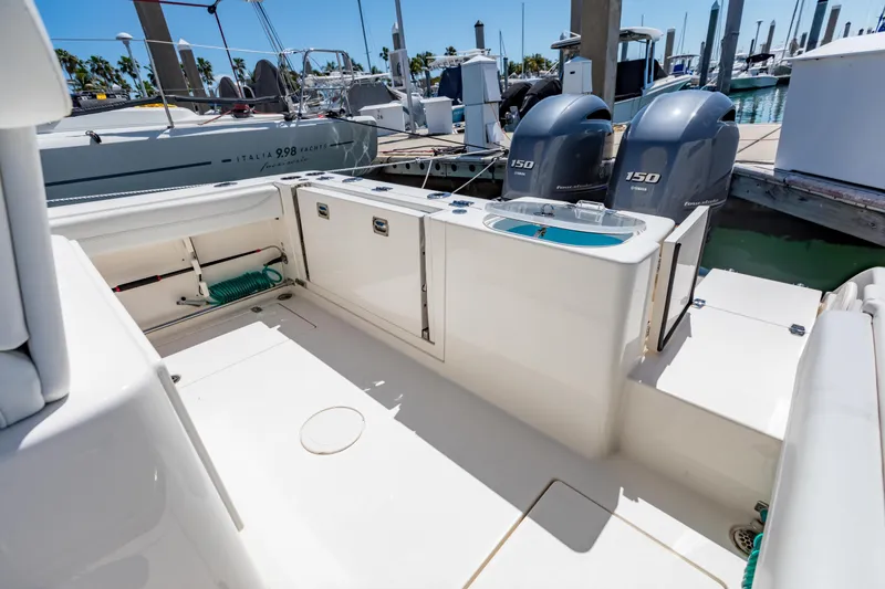 Slide: The Image of 2023 Cobia 240 Center Console boat interior with dual Yamaha 150 engines at marina. - 17