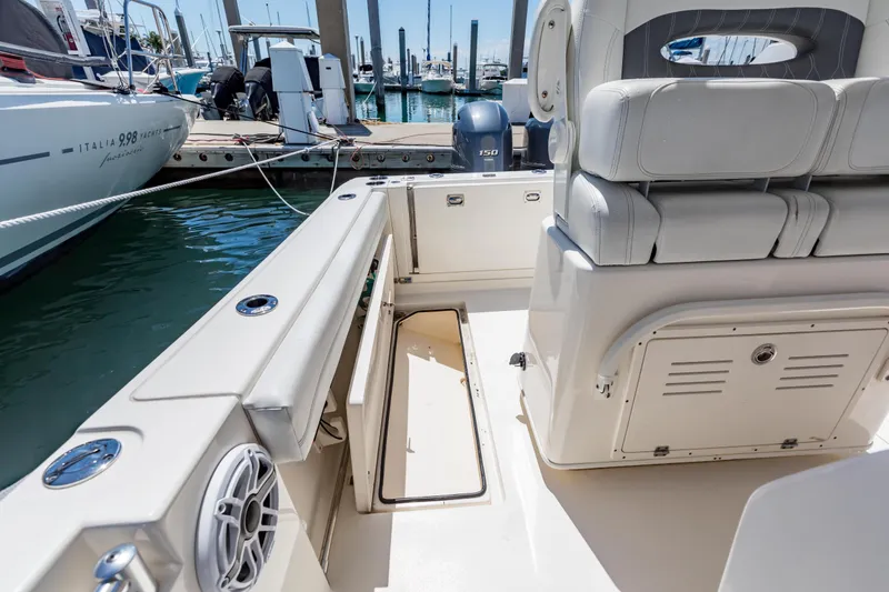 Slide: The Image of 2023 Cobia 240 Center Console boat interior with seating and storage, docked at marina. - 18