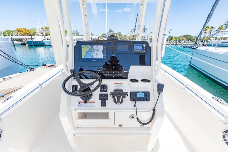 Slide: The Image of 2023 Cobia 240 Center Console boat dashboard with navigation equipment and steering wheel. - 23