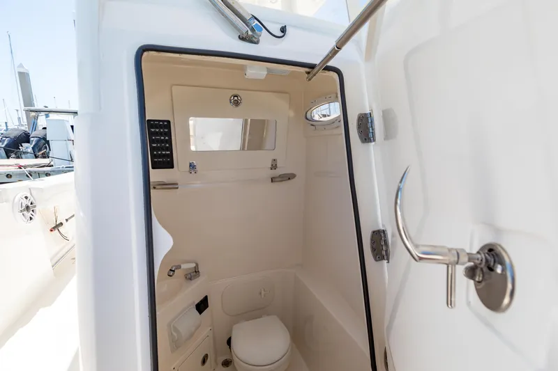 Slide: The Image of 2023 Cobia 240 Center Console boat interior with compact restroom facilities. - 27