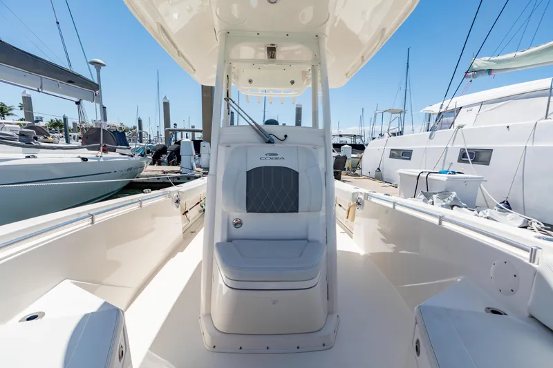 Slide: The Image of 2023 Cobia 240 Center Console boat docked at marina, showcasing sleek design and spacious seating. - 28
