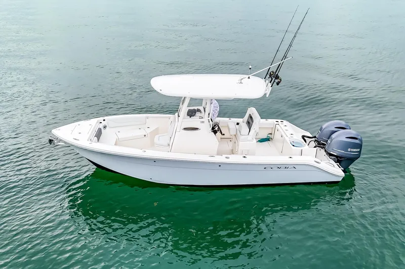 Slide: The Image of 2023 Cobia 240 Center Console boat on calm water, featuring dual Yamaha engines. - 3