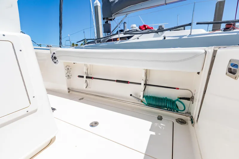 Slide: The Image of 2023 Cobia 240 Center Console boat interior with storage compartment and coiled hose. - 31