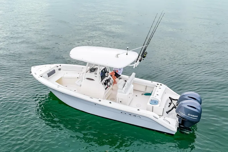 Slide: The Image of 2023 Cobia 240 Center Console boat on calm water with dual Yamaha engines. - 5