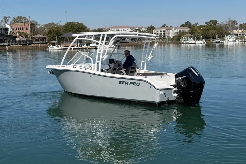 Slide: The Image of 2024 Sea Pro 240 Dual Console boat on calm water, featuring a Mercury outboard engine. - 16
