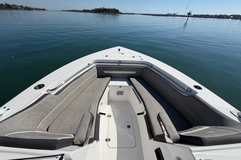 Slide: The Image of 2024 Sea Pro 240 Dual Console boat interior with cushioned seating on calm water. - 22