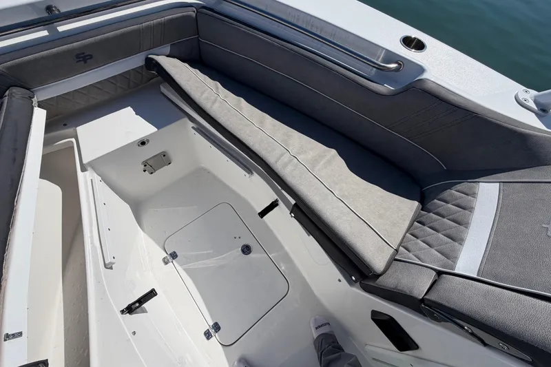 Slide: The Image of 2024 Sea Pro 240 Dual Console boat interior with cushioned seating and storage compartments. - 24