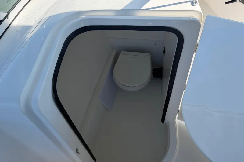 Slide: The Image of 2024 Sea Pro 240 Dual Console boat interior with compact marine toilet. - 27
