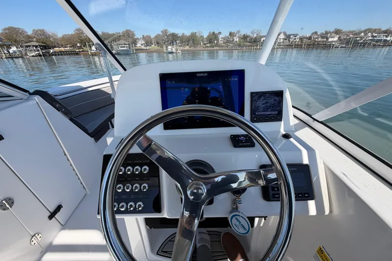 Slide: The Image of 2024 Sea Pro 240 Dual Console boat helm with modern navigation system on calm water. - 34