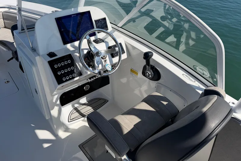 Slide: The Image of 2024 Sea Pro 240 Dual Console boat cockpit with steering wheel and control panel. - 39