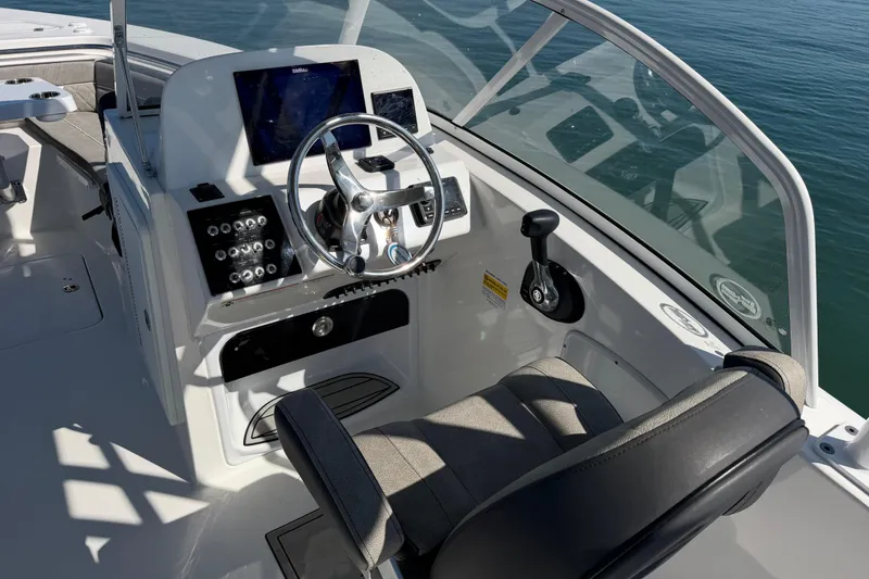Slide: The Image of 2024 Sea Pro 240 Dual Console boat cockpit with steering wheel and control panel. - 40