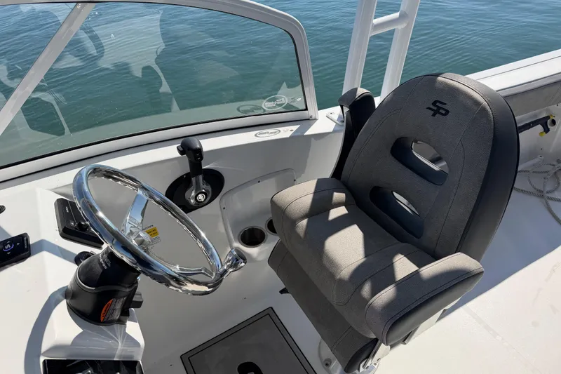 Slide: The Image of 2024 Sea Pro 240 Dual Console boat interior with steering wheel and captain's chair. - 42