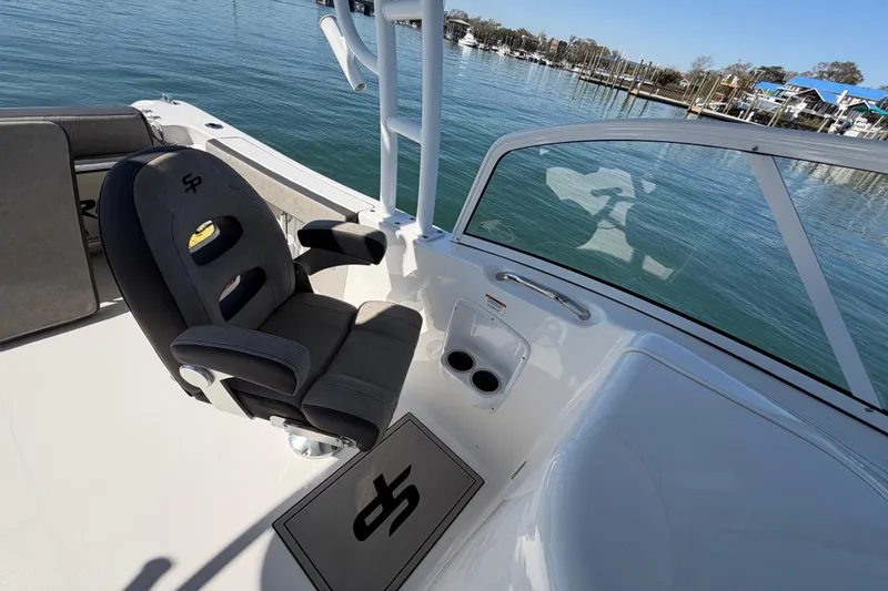 Slide: The Image of 2024 Sea Pro 240 Dual Console boat interior with captain's chair and waterfront view. - 45
