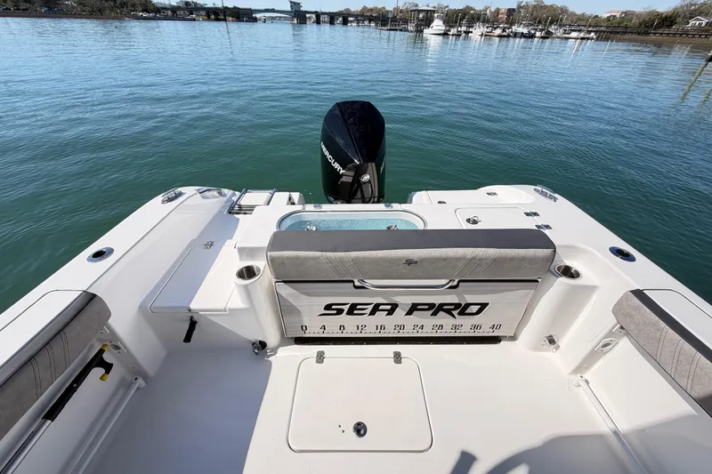Slide: The Image of 2024 Sea Pro 240 Dual Console boat on calm water, featuring spacious seating and Mercury engine. - 49