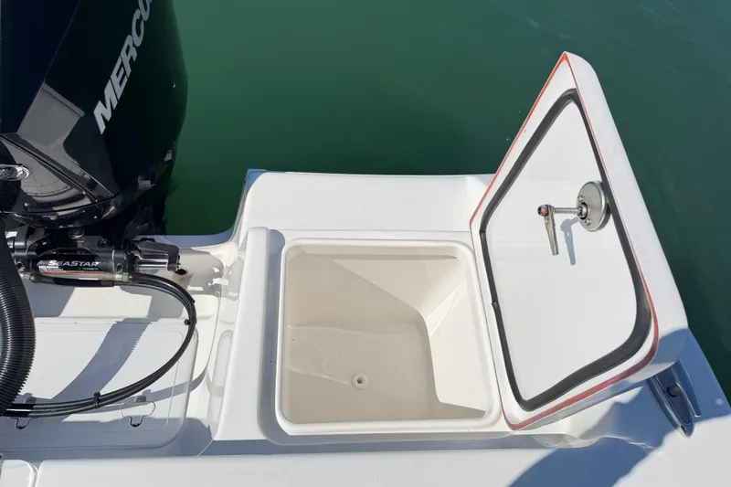 Slide: The Image of 2024 Sea Pro 240 Dual Console boat with open storage compartment and Mercury engine. - 53