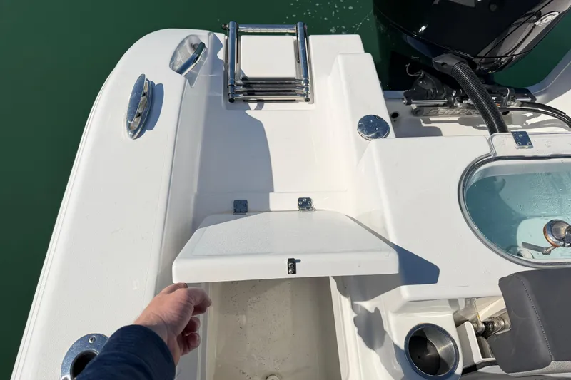 Slide: The Image of 2024 Sea Pro 240 Dual Console boat with open storage compartment and ladder on deck. - 57