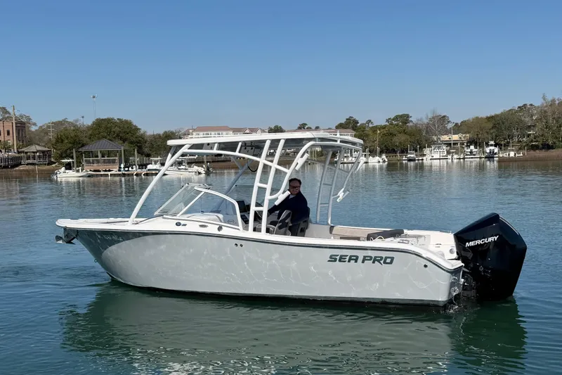 Slide: The Image of 2024 Sea Pro 240 Dual Console boat on calm water, featuring a Mercury engine. - 6